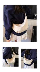 Detail view of the creamy white half-moon hobo bag featuring soft faux leather textures