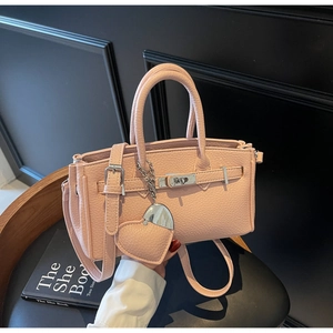 Detailed macro of pink lychee leather handbag featuring silver hardware and heart charm