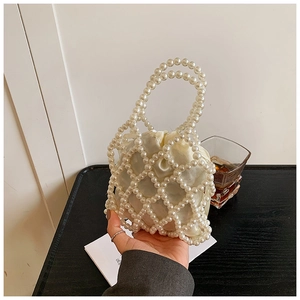Vue détaillée du sac à main en perles avec pochette en satin et texture tissée