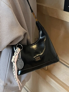 French style shiny black leather dumpling bag with gold lettering and tennis charm accessory