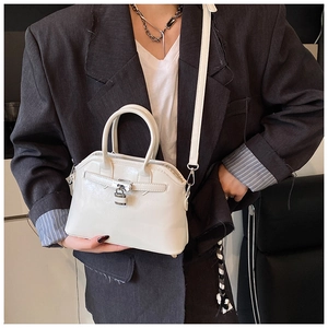 Detailed view of white shell bag with silver buckle and oil wax leather texture