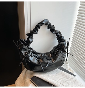 Détails du sac à bandoulière en cuir verni noir avec laçage croisé et poignée plissée chic