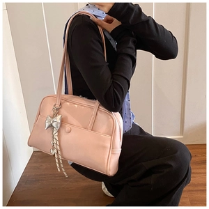 Detail of light pink PU leather bag with silver bow charm and heart pendant