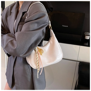 Detail of white vintage oil wax leather hobo bag with silk scarf and gold hardware