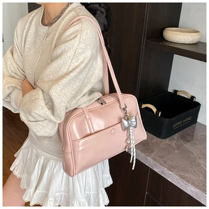 Detail of pink oil wax leather Boston bag with decorative silver bow charm
