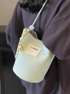 Sac seau vert menthe pour femmes avec motif litchi, pompon et écusson de la marque