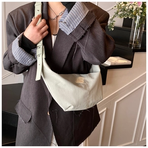 Detailed view of light green nylon hobo bag on shoulder showing its half-moon shape
