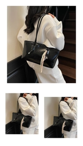 Close-up of black patent leather tote bag with MIKAXIO BAG FASHION embossed logo detail