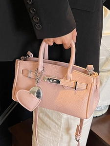 Pink lychee grain leather handbag with heart charm and silver chain for spring 2025 fashion