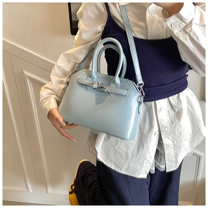 Close-up of light blue oil wax leather shell bag with silver buckle and top handle