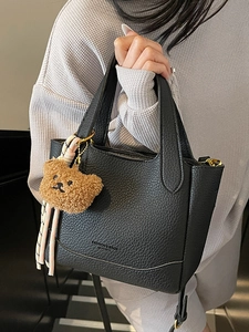 Chic black litchi pattern bucket bag with cute bear charm and woven rope detail