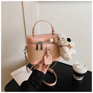 Pink box handbag featuring woven texture and a cute plush dog charm detail