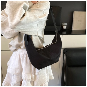 Close-up of black half-moon hobo bag in nylon material with silver zipper on model