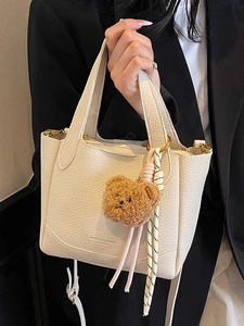 Chic white lychee pattern bucket bag with golden hardware and cute bear charm