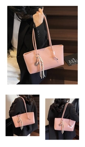 Detail of glossy pink tote bag with side knot tassel and embossed logo lettering