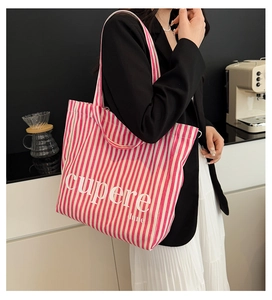 Detail of pink striped canvas tote bag showing the Cupere text and spacious design