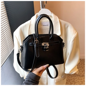 Close-up of black PU leather handbag featuring silver metal lock and adjustable strap