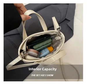 Interior view of small off-white bucket bag showing storage for wallet and cosmetics