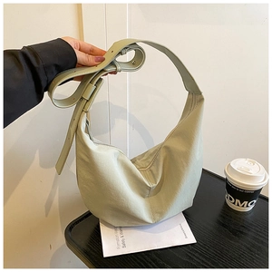 Detail view of mint green hobo bag with adjustable wide strap and metallic eyelet accents