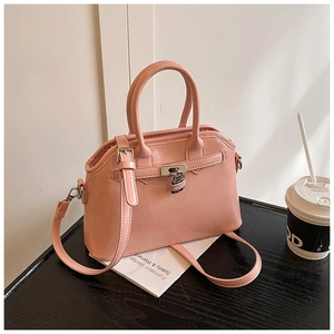 Detail of pink oil-wax leather shell bag with silver padlock and smooth texture