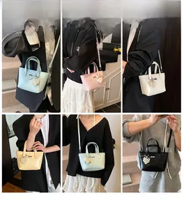 Detail view of macaron colored crossbody bucket bags featuring pearl heart charms and straps