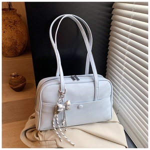 Detail of light blue PU leather Boston bag with silver bow pendant and long handles
