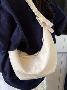 Minimalist beige crescent shoulder bag with pleated texture and adjustable strap for women
