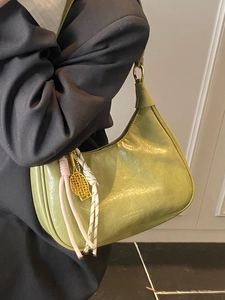 Green oil wax leather tote bag with vintage texture and stylish tennis racket pendant accessory