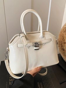 Elegant cream shell handbag with top handle and crossbody strap in polished oil wax leather