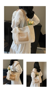 Detail of woven straw tote bag with Summer patch and lace bow decoration
