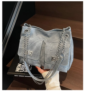Vue détaillée du sac en jean avec deux poches avant et fermoirs rotatifs argentés