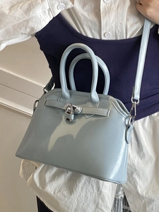Elegant light blue glossy shell bag with top handles and adjustable shoulder strap