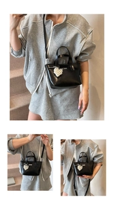 Three-way view of a black bucket bag with a pearl heart charm and shoulder strap
