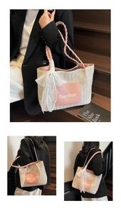 Detail of woven tote bag with pink leather pocket and white lace bow decoration