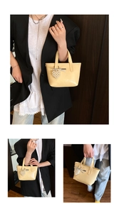 Detailed views of yellow bucket bag with pearl heart charm and metallic bow detail