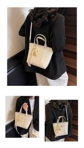 Detail view of cream tote bag with embossed cartoon bears and decorative scarf pendant