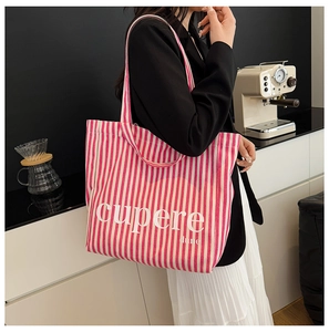 Detail view of pink and white striped canvas tote bag with artistic letter print