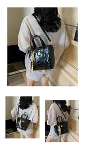 Macro detail of black patent leather bucket bag with embossed cartoon bear and tassel