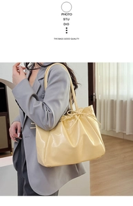 Close-up of cream yellow soft leather tote bag featuring elegant drawstring bow detail