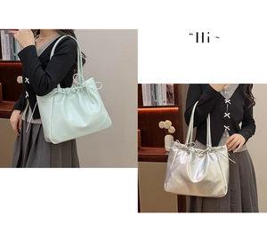 Detail of soft leather tote bag showing drawstring bow accents and metallic silver finish