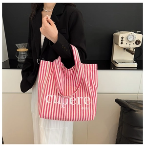 Detail view of the pink and white striped canvas tote bag with cupere text print