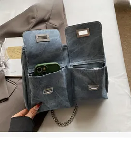 Détail du sac cabas en jean avec poches avant durables et fermeture par boucle en métal argenté