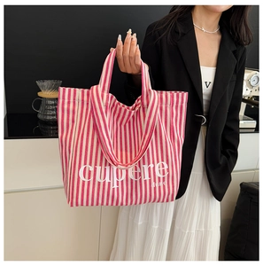 Close-up of pink and white striped canvas tote bag featuring cupere letter print