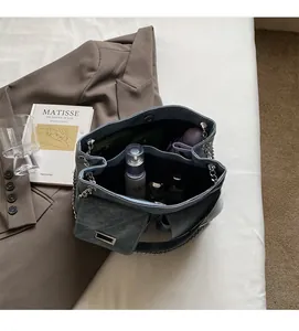 Vue intérieure du sac cabas en denim avec bandoulière chaîne et compartiments spacieux