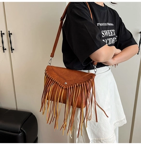 Detail of bohemian brown faux leather envelope bag with long tiered fringe and metal buckle