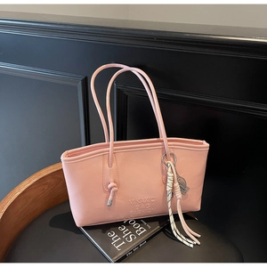 Pink PU leather bucket bag detail with letter embossing and woven rope pendant
