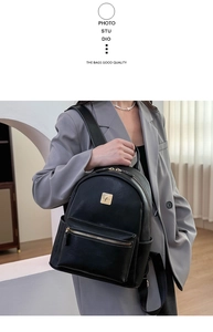 Detail of minimalist black PU leather backpack with gold hardware and logo on side pocket