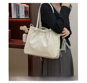 Detail of soft cream leather tote bag with drawstring bow and spacious interior