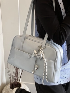 Light blue oil wax leather Boston bag with silver bow charm and shoulder strap