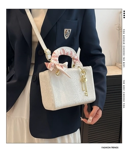 Détail du sac blanc à motif lézard avec foulard en soie et bandoulière amovible